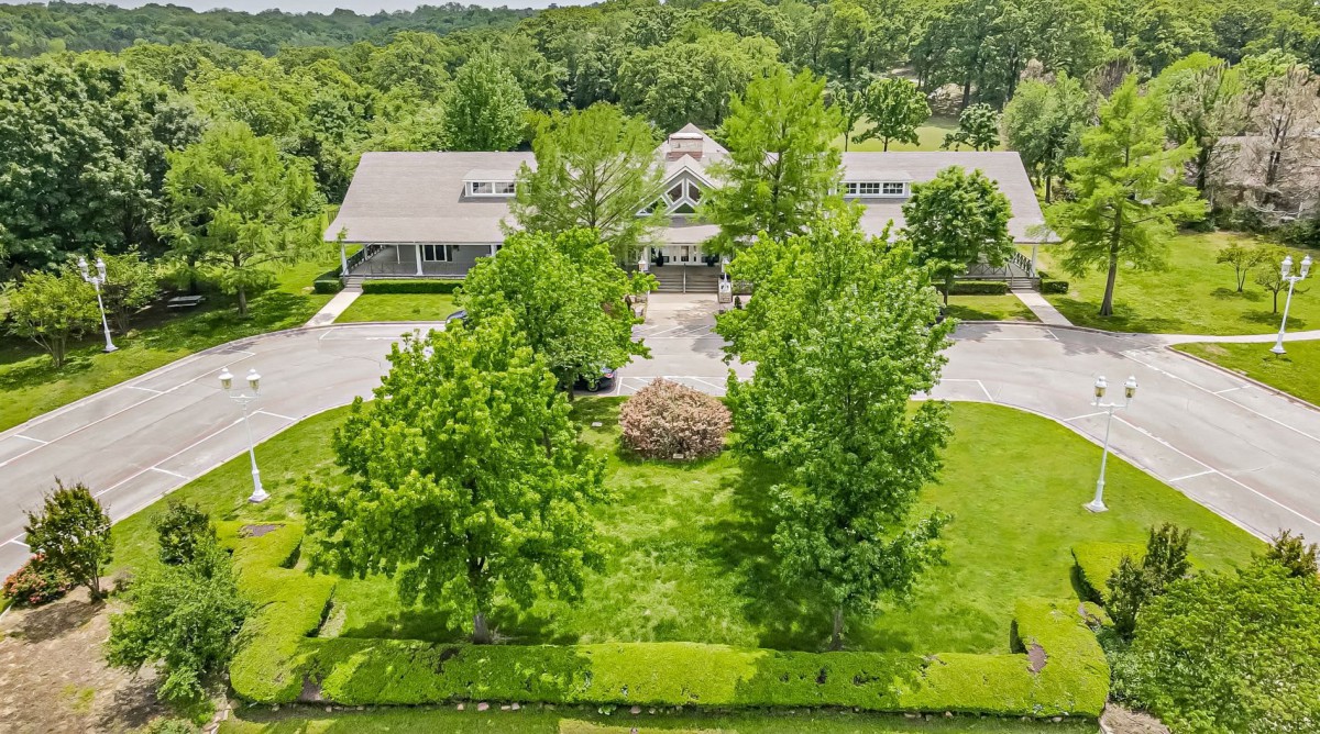 Aerial view of a building surrounded by lush greenery and trees.
