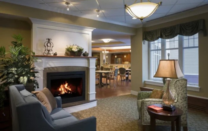 A cozy living room with a fireplace and comfortable seating, elegantly decorated in warm tones.