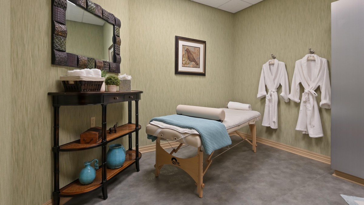 A tranquil spa room with a massage table and robe, designed for relaxation.