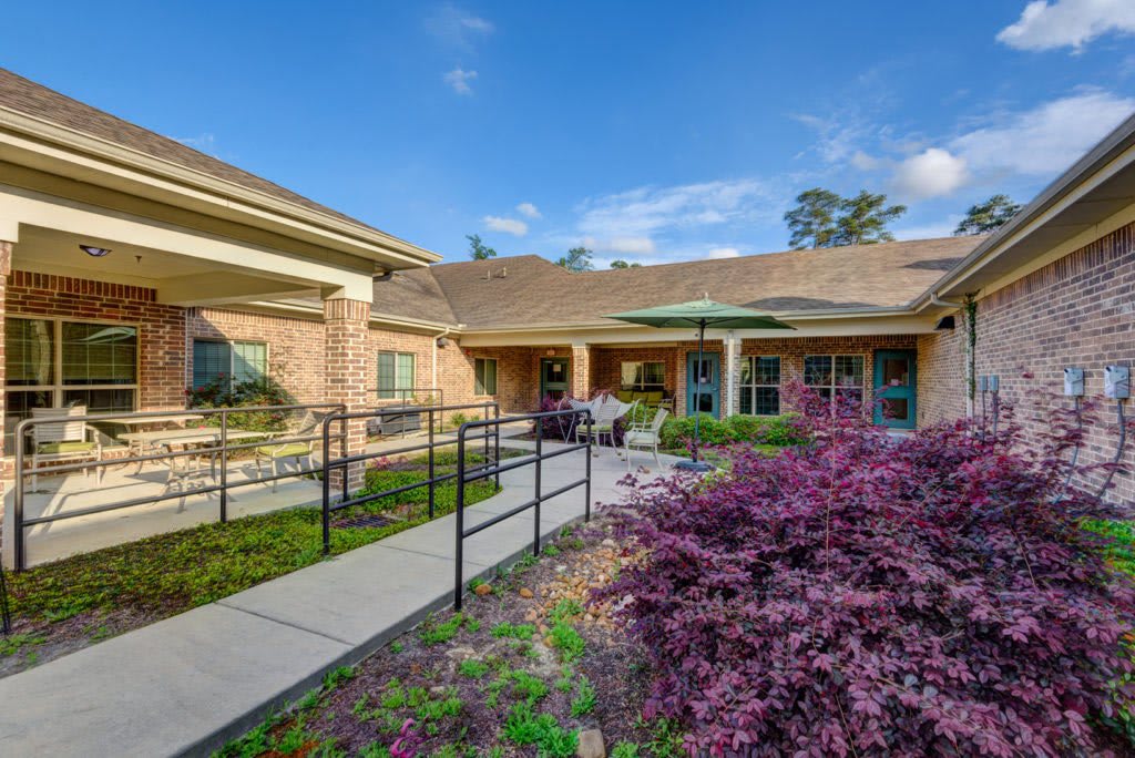 A charming building with a garden and walkway on a sunny day.