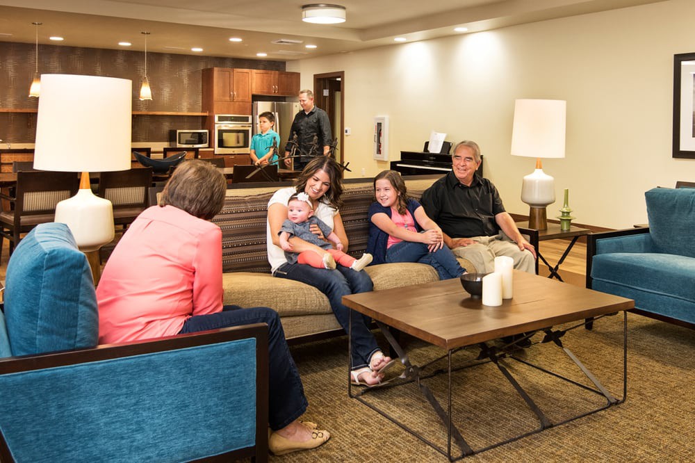 A family gathered in a cozy living room, engaging in conversation.