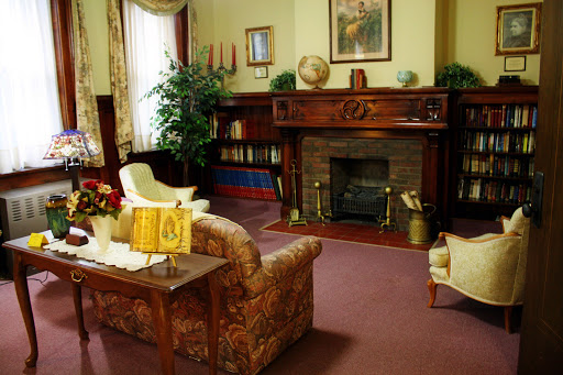 A cozy and elegant living room featuring a classic fireplace and comfortable seating.