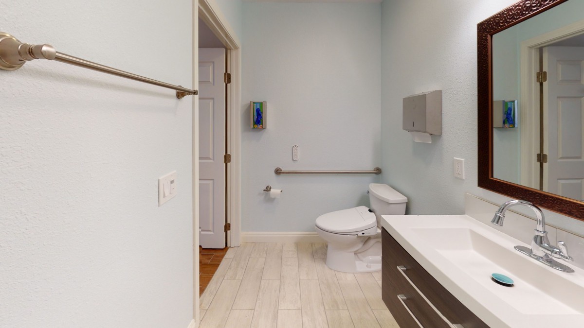 Modern bathroom with light-colored tiles and accessible features.