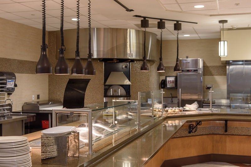 Interior view of a modern cafeteria kitchen with serving counters.