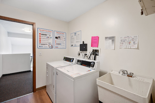 A well-equipped laundry room featuring washing machines and a utility sink.