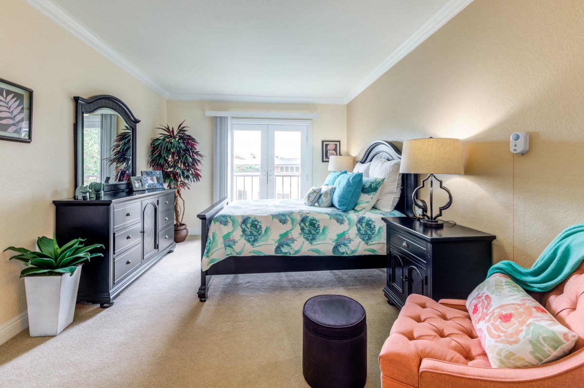 A cozy bedroom with elegant furnishings and a large window letting in natural light.
