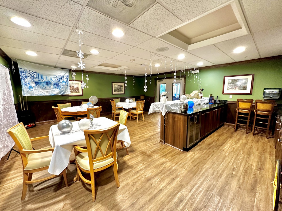 A cozy restaurant interior with neatly arranged tables and chairs, featuring a warm wooden floor and tasteful decor.