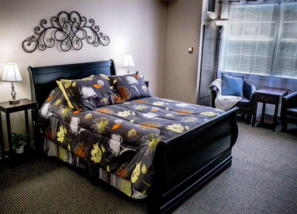 A cozy bedroom with a patterned bedspread and elegant decor.