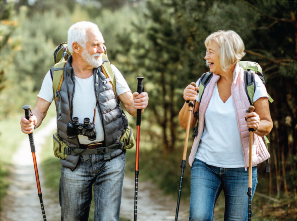An elderly couple hiking through a forest trail, enjoying nature and staying active.