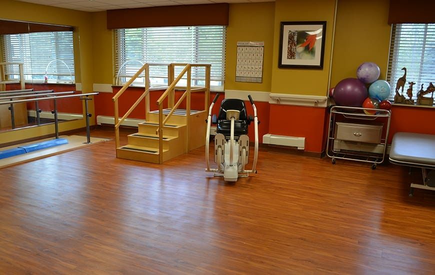 A physical therapy and rehabilitation room featuring exercise equipment and training stairs.