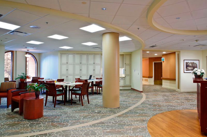 A modern meeting room with a large conference table and comfortable seating, featuring contemporary design and bright lighting.