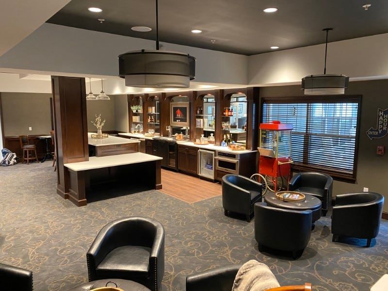 A modern lounge with comfortable seating and a kitchen area.
