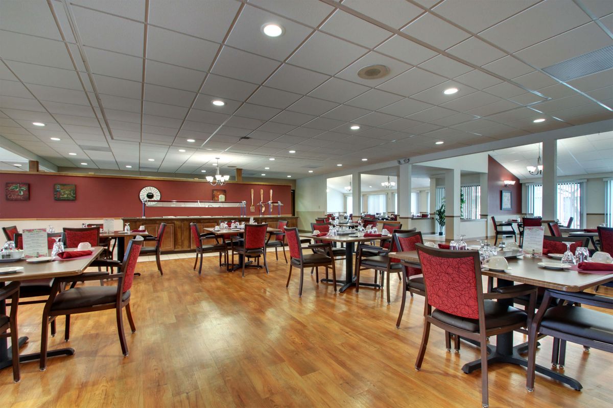A modern, elegantly decorated restaurant dining area with neatly arranged tables and chairs on a wooden floor.