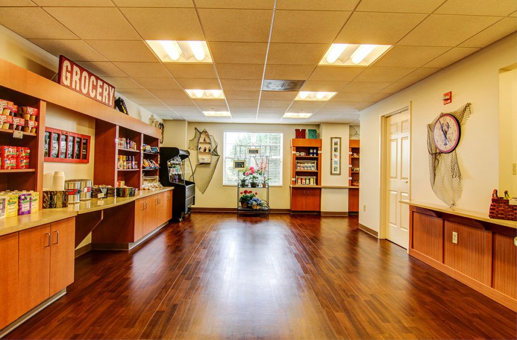 A modern office reception area with wooden floors and shelving.