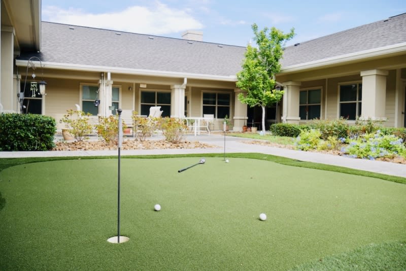 A well-maintained putting green in a courtyard setting.