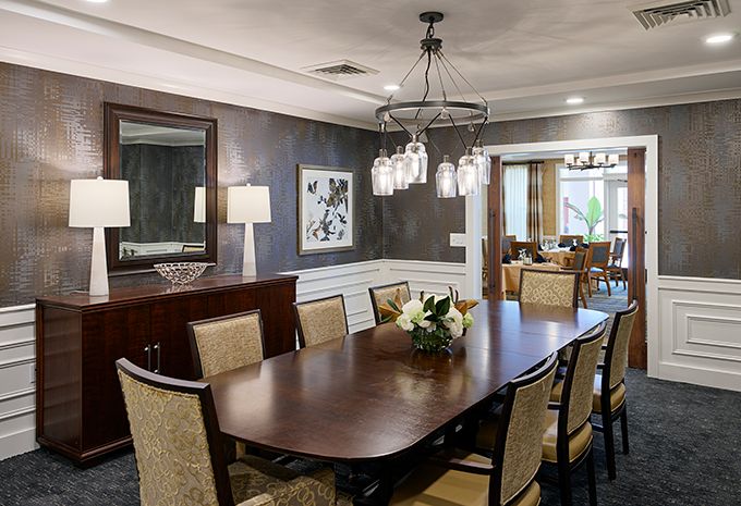 A well-appointed dining room with a wooden table, upholstered chairs, and elegant lighting.