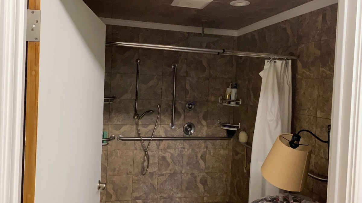 A bathroom featuring a shower with a curtain and tiled walls.