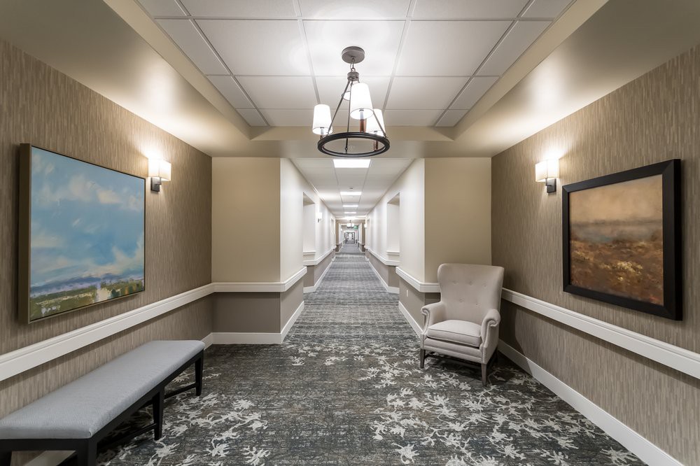 A well-lit hotel hallway with elegant decor and comfortable seating.