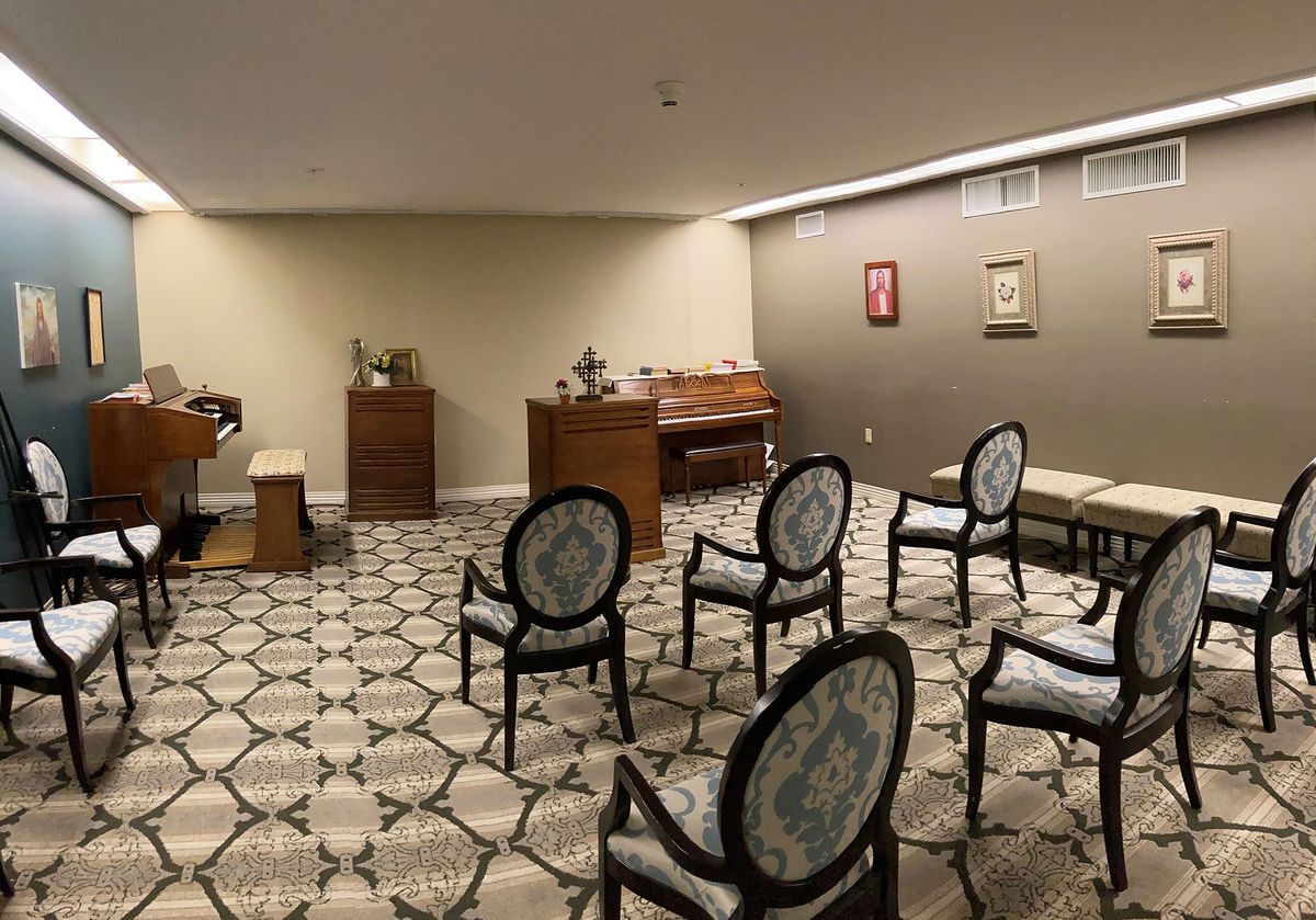A small, elegantly furnished room with chairs arranged facing an organ.