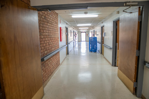 A well-lit hospital corridor featuring smooth walls and doors, creating a clean and organized environment.