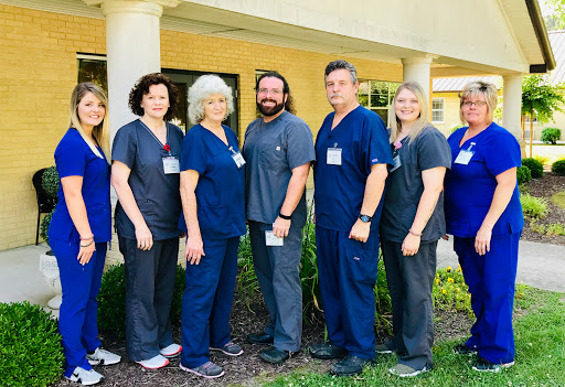 A dedicated healthcare team posing together in front of their facility.