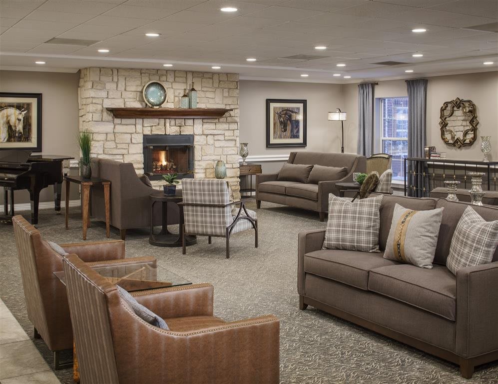 A cozy living room featuring comfortable sofas, a stone fireplace, and elegant home decor.