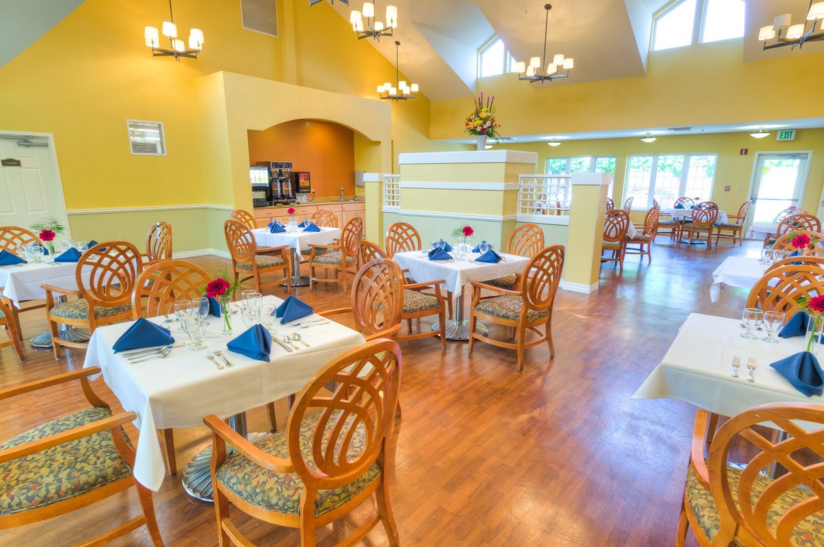 A well-lit dining area with neatly arranged tables and chairs.