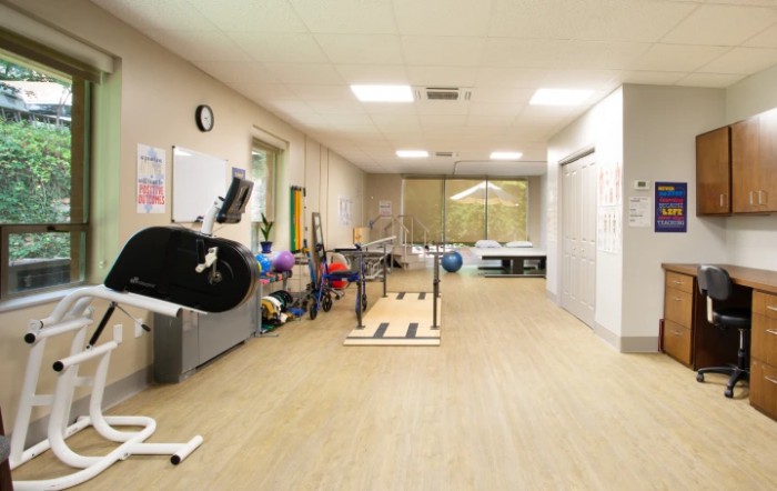 A spacious gym with various exercise equipment and facilities for fitness training.