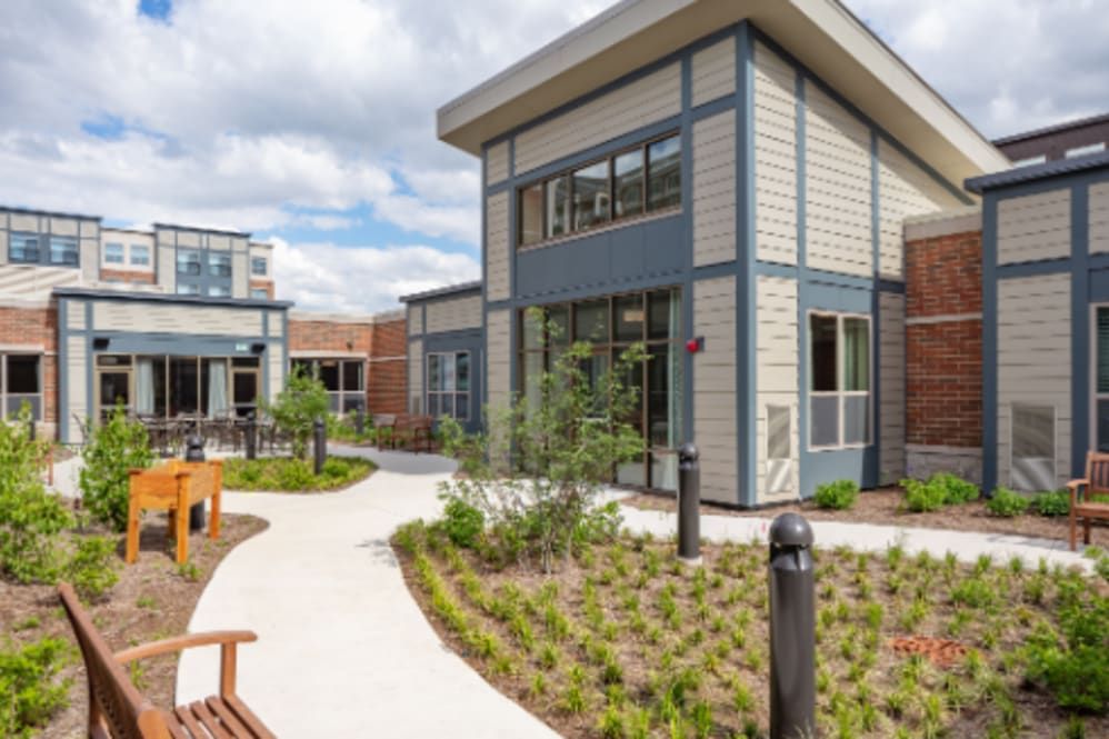 A modern architectural building with landscaped pathways and benches.
