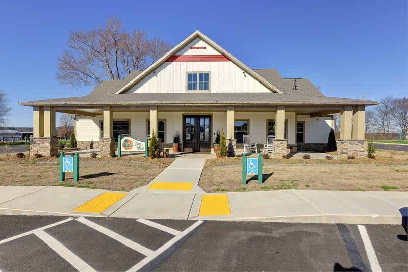 A quaint house with a spacious front yard and a clear blue sky overhead.