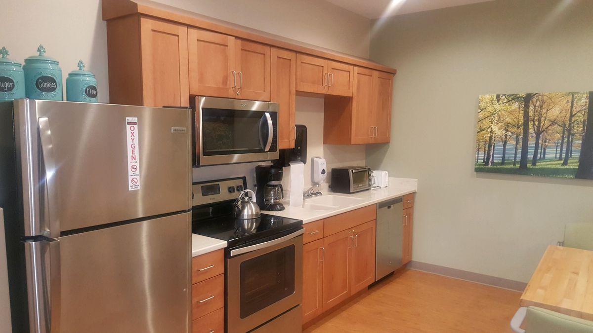 Modern kitchen with stainless steel appliances and wooden cabinets.