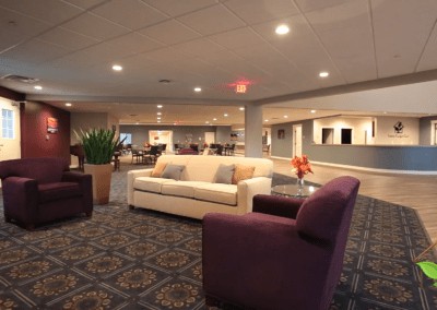 A spacious lobby area featuring comfortable sofas and armchairs, soft lighting, and stylish decor.