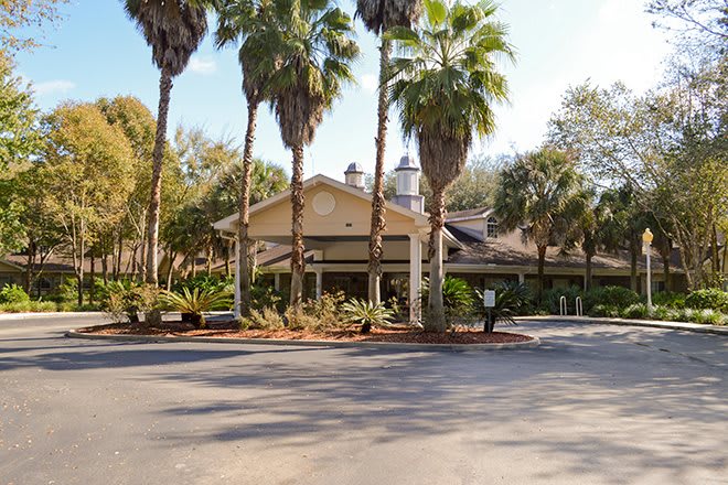 A tropical building surrounded by palm trees on a sunny day.