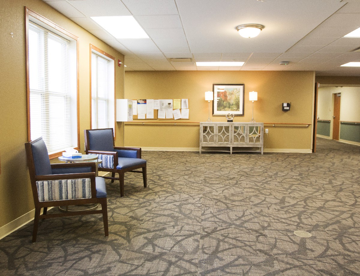 A quiet lobby area with chairs and carpeted flooring.