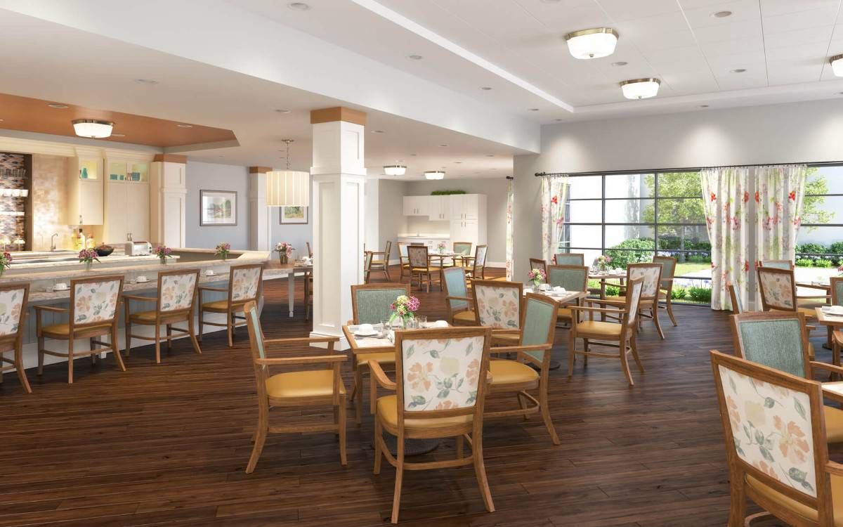 A spacious and well-lit dining area with wooden tables and chairs, featuring elegant decor and a warm ambiance.