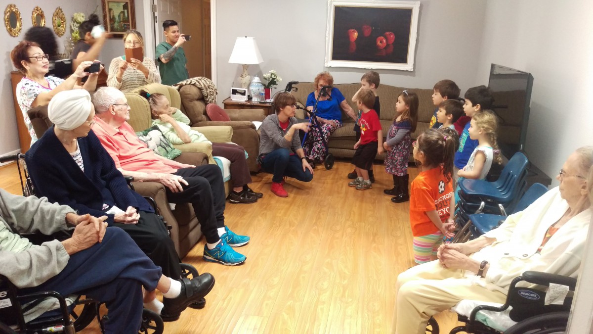 A family gathering in a living room with children and adults socializing.