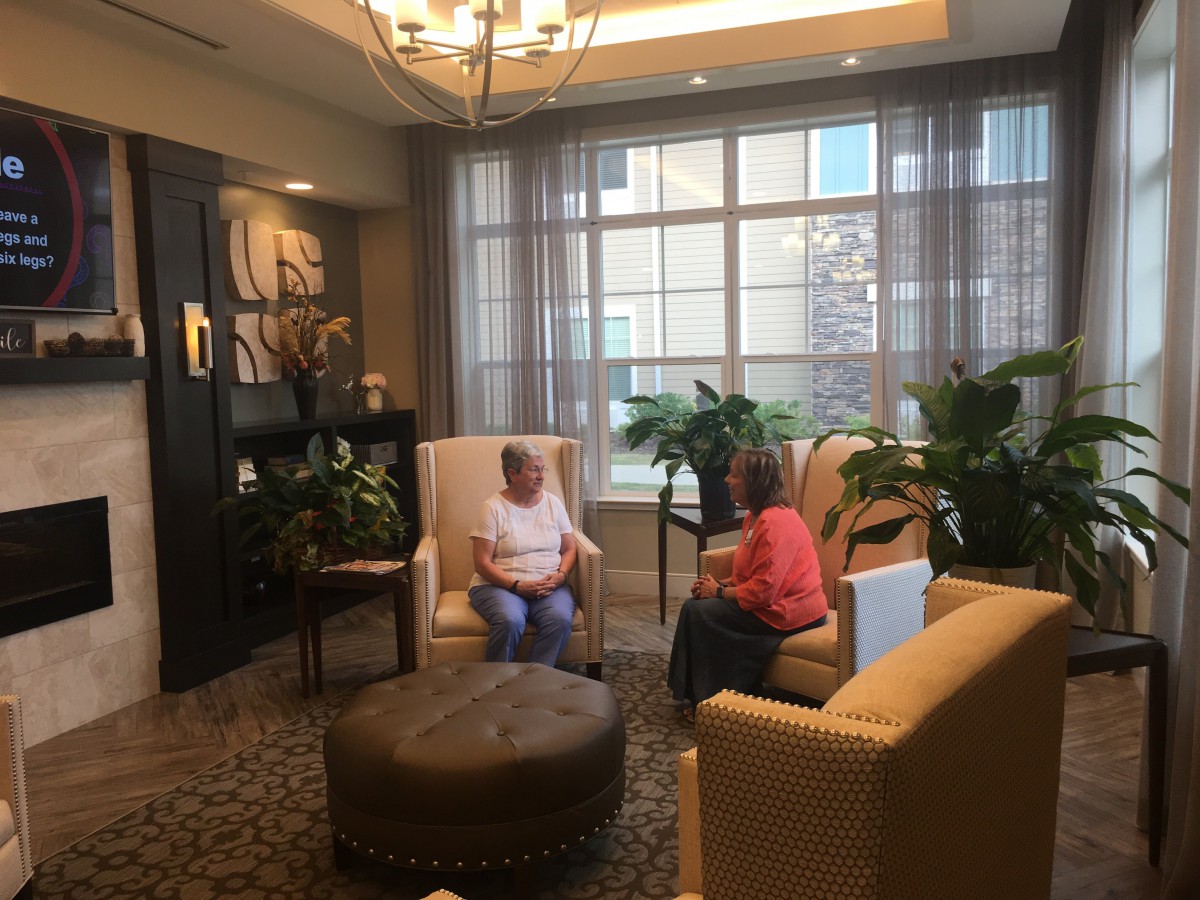 Two people sitting in a cozy lounge area having a conversation.