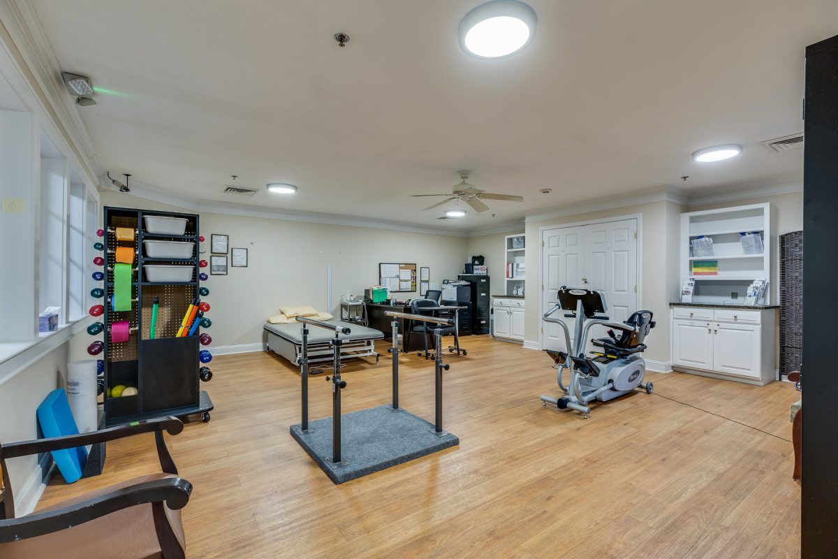 A spacious physical therapy and rehabilitation room equipped with various exercise machines and facilities.