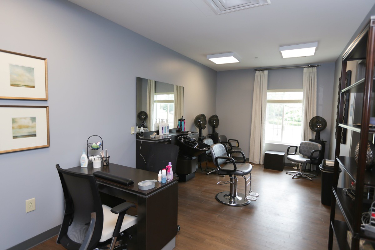 Interior of a modern hair salon with styling stations and comfortable seating.