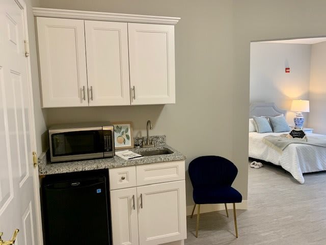 A cozy kitchenette with a view into the bedroom, featuring a microwave and mini fridge.