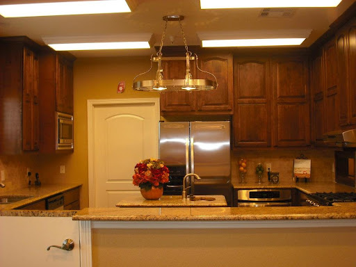 A modern kitchen featuring wooden cabinets, stainless steel appliances, and warm lighting.