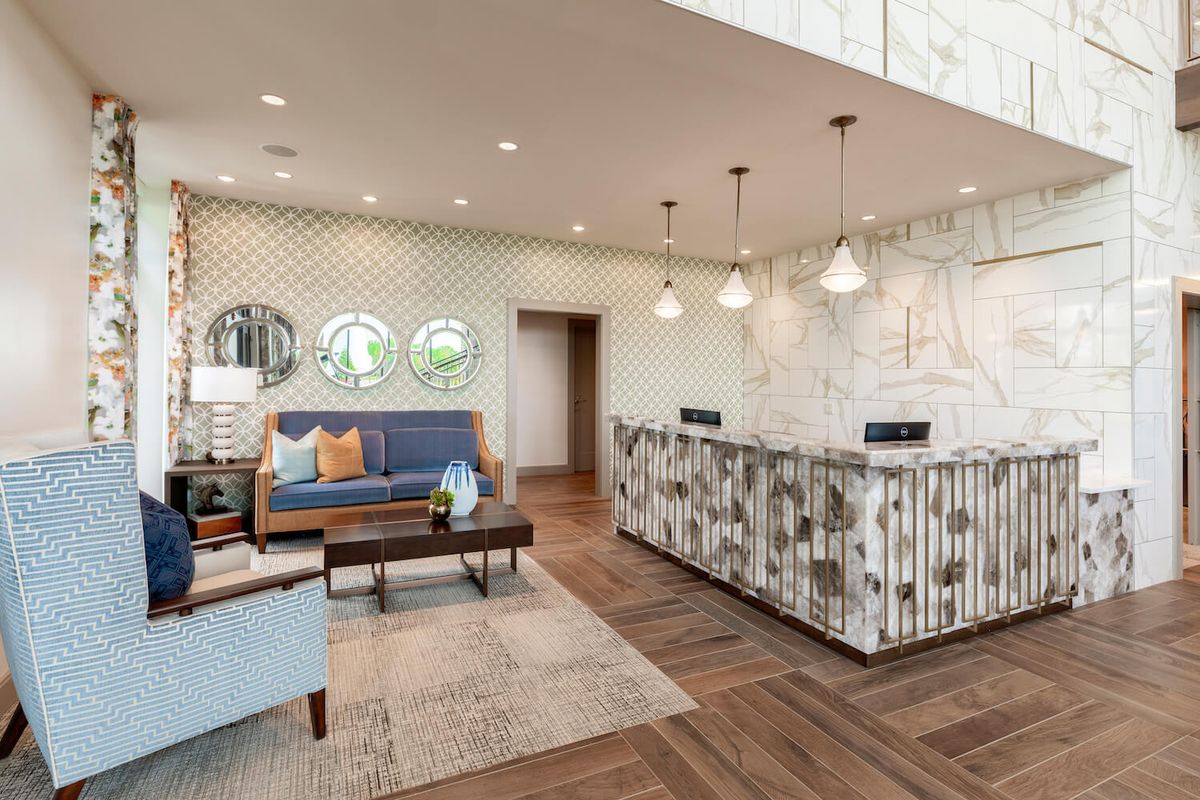 A stylish and modern hotel lobby with a check-in desk and comfortable seating area.
