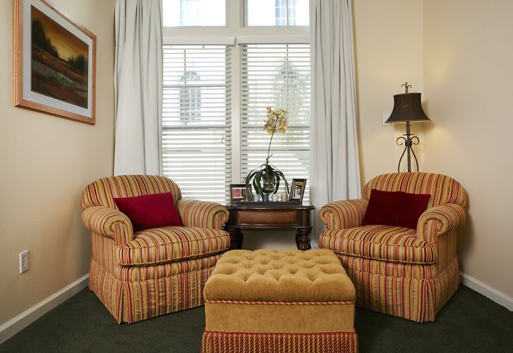 Cozy living room with armchairs and an ottoman by the window.