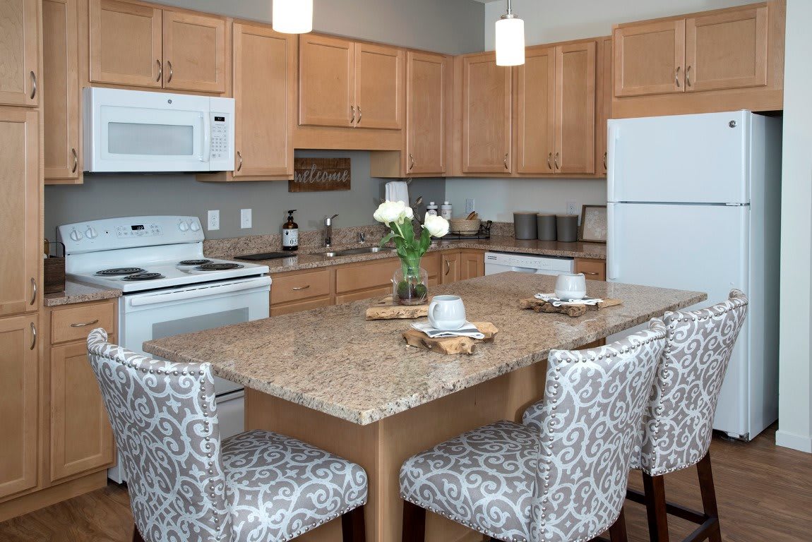 A modern kitchen featuring a central island with patterned stools and contemporary appliances.