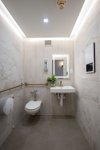 A sleek and modern bathroom featuring a compact sink, toilet, and minimal decor.