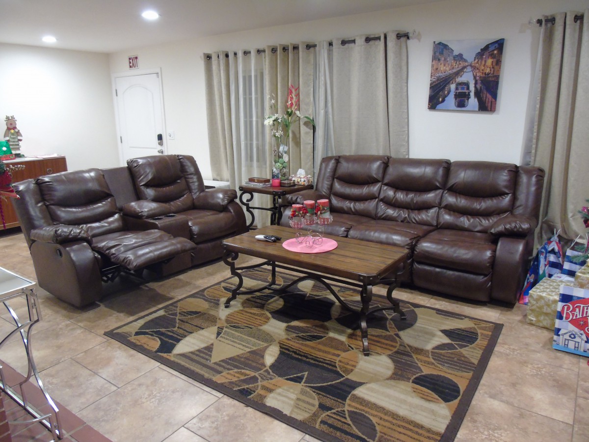 A cozy living room with leather sofas and a patterned rug.