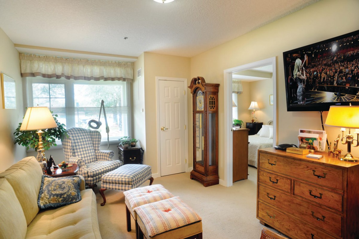 A cozy living room with classic furniture and a grandfather clock.
