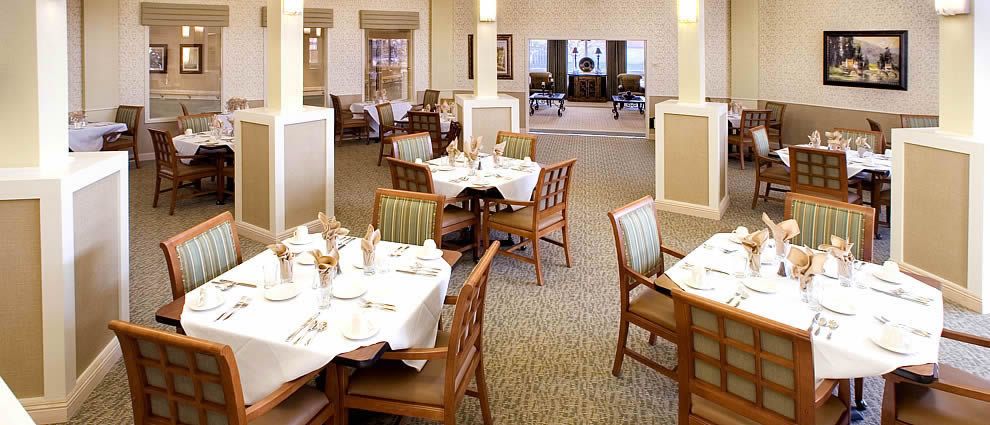 An elegant dining room setup with neatly arranged tables and chairs.