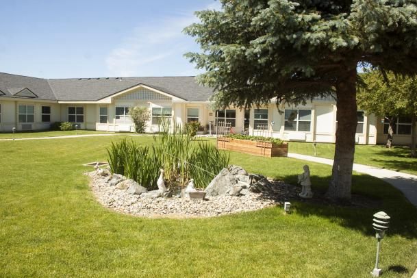 A landscaped garden with a small pond in front of a building.
