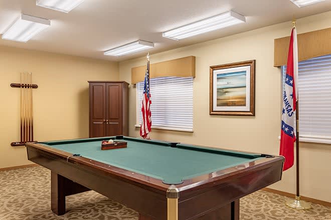 A billiards room featuring a pool table, an American flag, and framed artwork on the wall.